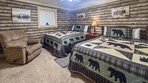 Ein Schlafzimmer im Chalet-Stil mit zwei Betten, einem Liegesessel, einem Deckenventilator und Wandbildern.
