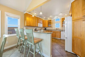 A kitchen with wooden cabinets, a central island, and bar stools.