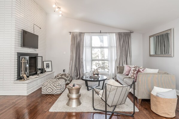 Una sala de estar moderna con chimenea, televisor, sofá y mesa de centro.