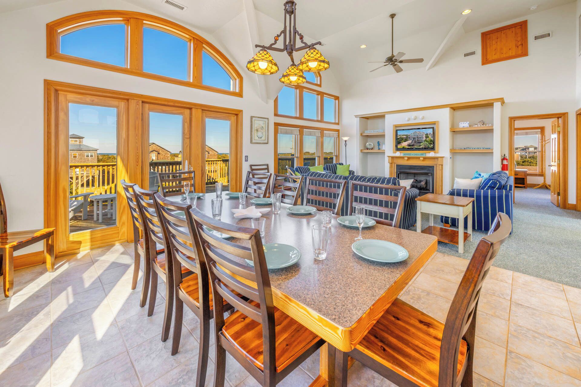 A spacious dining area with a large table and chairs, a fireplace, and a balcony with a view of the city.