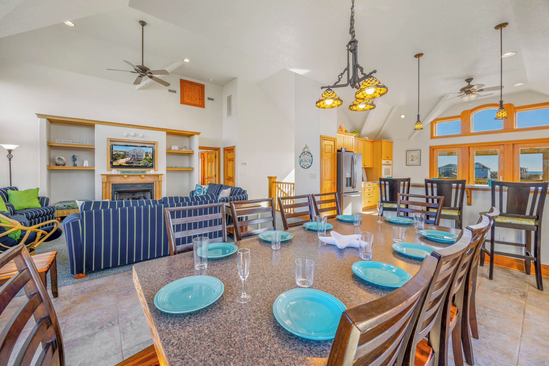 A spacious dining area with a long table set for six, surrounded by wooden chairs.