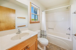 Ein Badezimmer mit Waschbecken, Toilette und Badewanne.