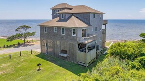 A two-story building with a balcony and a view of the sea.