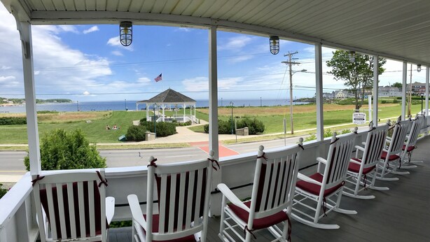 A porch with white rocking chairs and a gazebo with an American flag. - Diane Cottage, York Manor, Short Sands Beach (York)