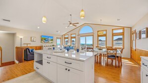 Una cocina espaciosa con una isla grande, piso de madera y un comedor con vistas.