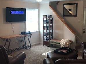 Relax in this inviting living room with a flat-screen TV, comfortable sofa, and cozy armchair.