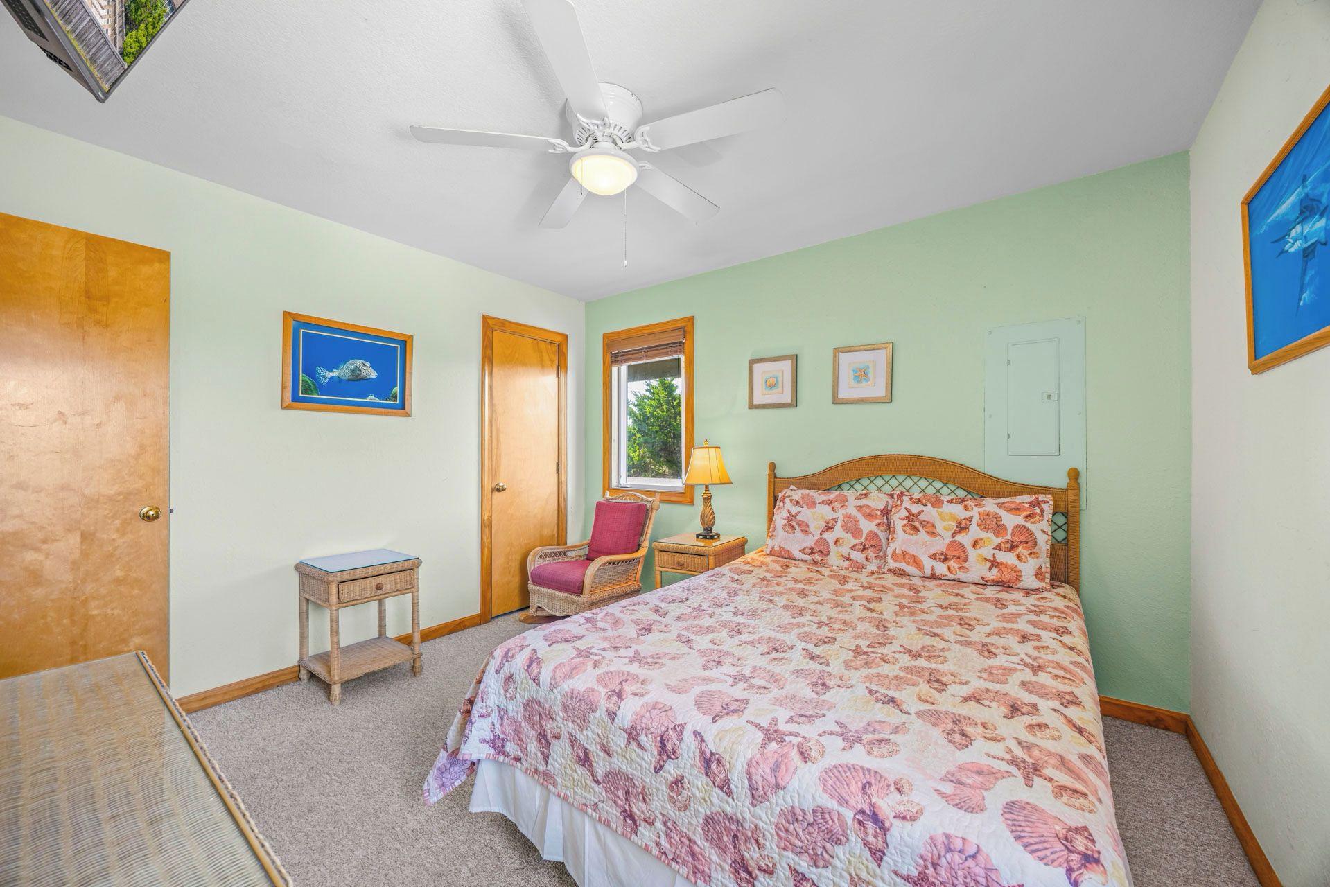 Un dormitorio con cama, ventilador de techo, ventana y puerta.