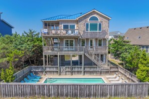 A two-story house with a balcony, a swimming pool, and a deck. - Oceanfront Dog Friendly Home in Salvo w/ Private Pool, Hot Tub, and Game Room (Salvo)