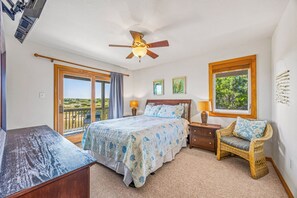 A bedroom with a bed, a chair, a desk, a ceiling fan, and a window with a view. - Oceanfront Dog Friendly Home in Salvo w/ Private Pool, Hot Tub, and Game Room (Salvo)