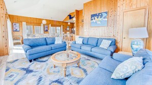 A spacious living room with two blue sofas, a round coffee table, and a wooden ceiling. - Oceanfront Dog Friendly Home in Salvo w/ Private Pool, Hot Tub, and Game Room (Salvo)