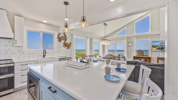 A spacious kitchen with a large island, modern appliances, and large windows offering ocean views. - Oceanfront Dog Friendly Home with Private Pool, Hot Tub, Direct Beach Access (Avon)