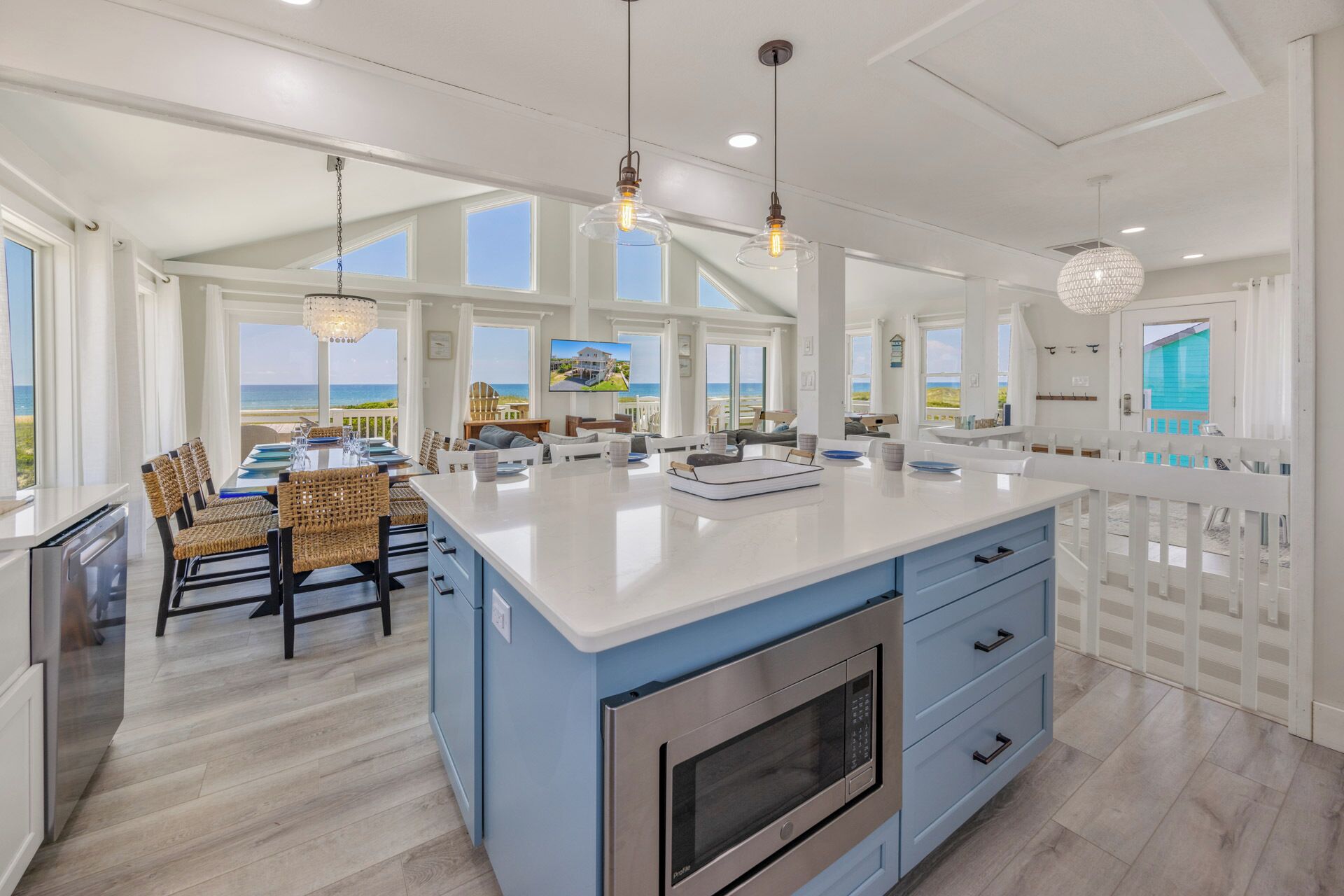 A spacious kitchen with a large island, modern appliances, and large windows offering ocean views.