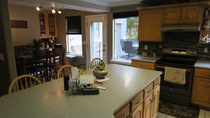 A kitchen with wooden cabinets, a large island, and a built-in oven.