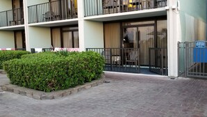 Un immeuble à plusieurs étages doté de balcons, d’une entrée sécurisée et d’un panneau indiquant qu’il est interdit d’utiliser des radios ou de diffuser de la musique amplifiée.