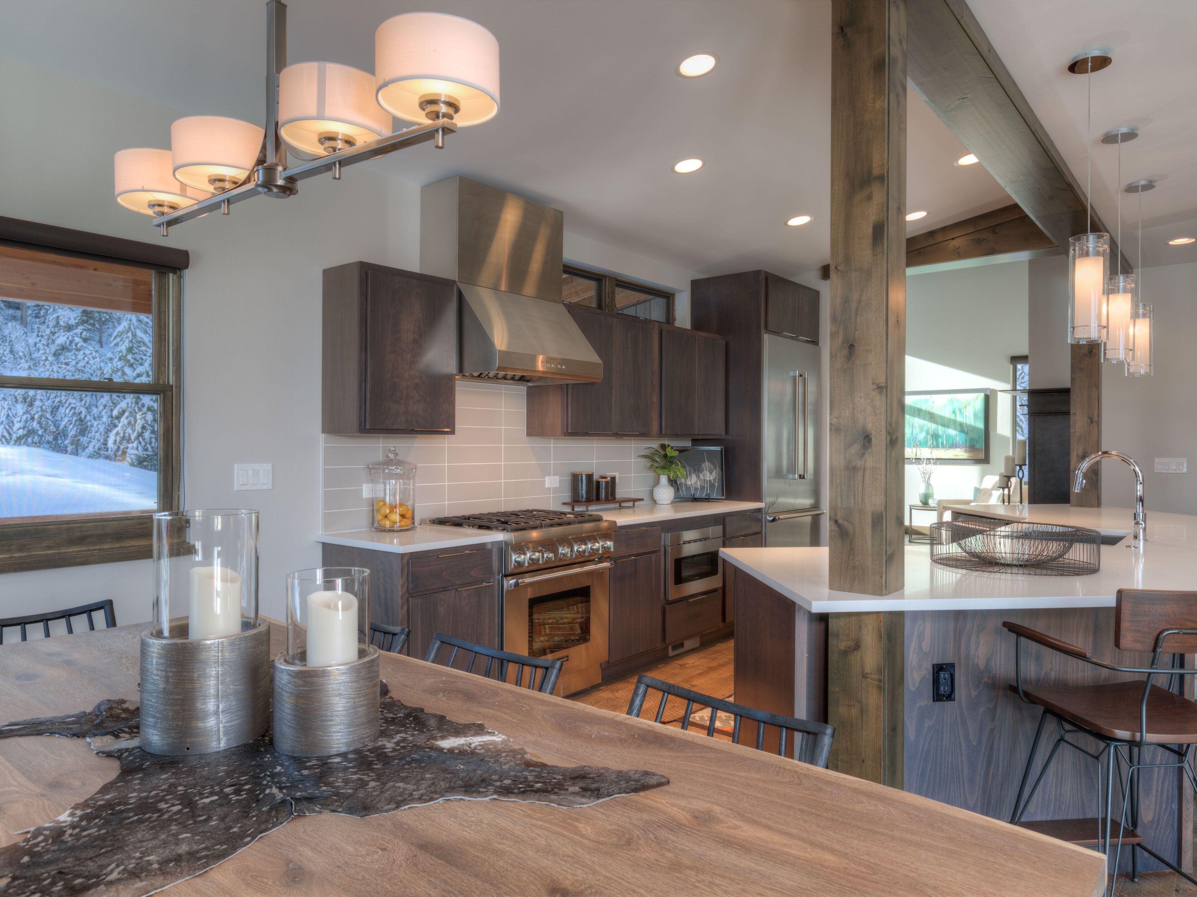 Una cocina moderna con armarios de madera oscura, electrodomésticos de acero inoxidable y una isla grande con taburetes de bar.