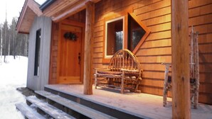 A wooden cabin with a porch, a wooden bench, and a ladder. - Beautiful eco-building in the heart of the Rocky mountains. All modern amenities (golden)