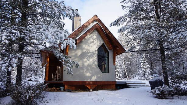 A small, modern cabin with a steeply pitched roof, surrounded by snow-covered trees. - Beautiful eco-building in the heart of the Rocky mountains. All modern amenities (golden)