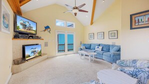 A living room with a television, a sofa, and a coffee table. - Oceanview Dog Friendly Home with Private Pool, Hot Tub, Elevator, Game Room (Avon)