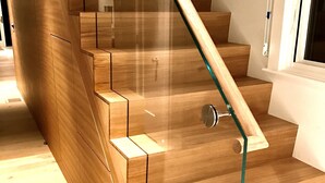 A wooden staircase with glass railings and a modern design. - Spectacular Beachfront West End Home  (Provincetown)