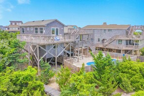 A multi-story wooden building with outdoor decks and a pool.