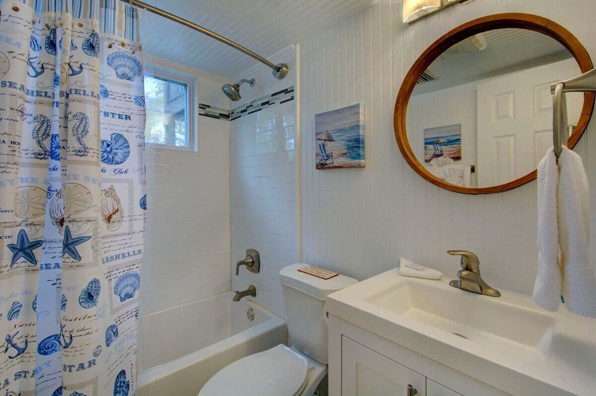 A bathroom with a bathtub, toilet, sink, and a shower with a curtain.