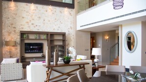 A modern living room with a flat-screen TV, comfortable seating, a dining area, and a staircase leading to an upper level. - Grand Luxxe Riviera Maya 3 Bedroom Residence (SPRING BREAK 2020 - 3/14-21) (Riviera Maya)
