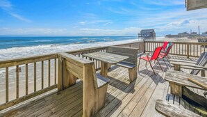 A wooden deck with picnic tables and chairs overlooking the beach. - Cozy Oceanfront Cottage w/ Books, Games, TVs, Stunning Views. Right on the Beach (Rodanthe)