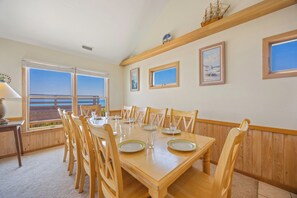 A dining room with a large table, chairs, and a view of the ocean. - Oceanfront Home in Avon with Hot Tub, Community Pool and Tennis/Pickleball (Avon)