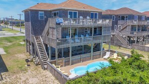 Una casa de dos pisos con balcón, piscina y vista al mar.
