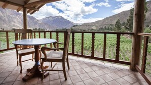 Eine Holterrasse mit Tisch und Stühlen mit Blick auf eine Berglandschaft.