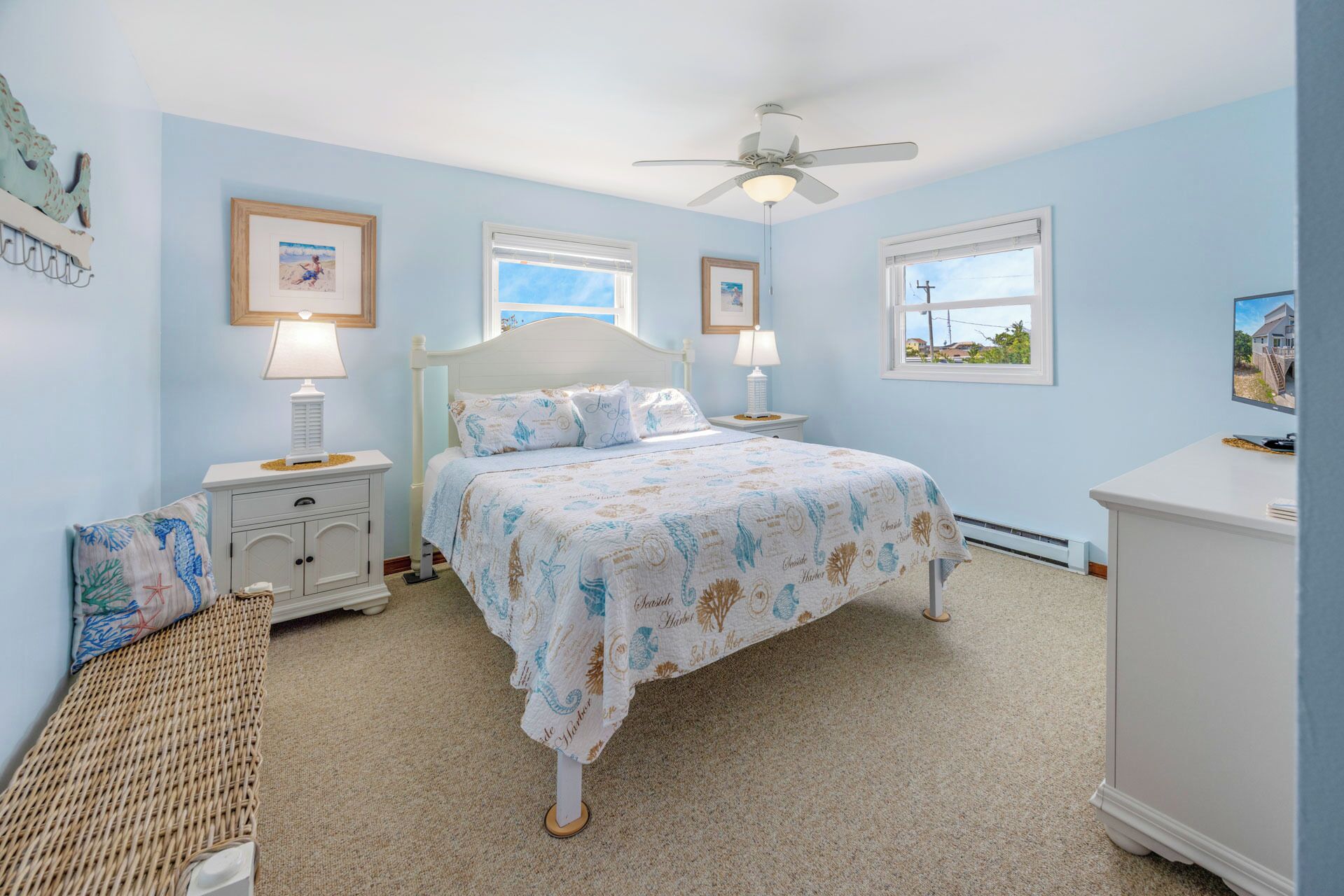 A bedroom with a bed, two bedside tables, a ceiling fan, and a dresser.