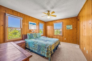 A bedroom with a bed, a desk, a chair, a ceiling fan, and large windows. - Oceanfront Home with Direct Beach Access, Community Pool and Tennis/Pickleball (Avon)