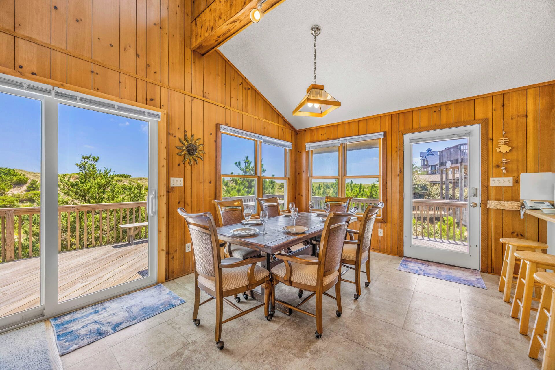 A dining area with a large table, chairs, and a view of the outdoors.