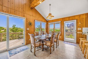 A dining area with a large table, chairs, and a view of the outdoors. - Oceanfront Home with Direct Beach Access, Community Pool and Tennis/Pickleball (Avon)