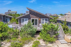 A beachfront property with a wooden deck, a covered patio, and a view of the ocean. - Oceanfront Home with Direct Beach Access, Community Pool and Tennis/Pickleball (Avon)