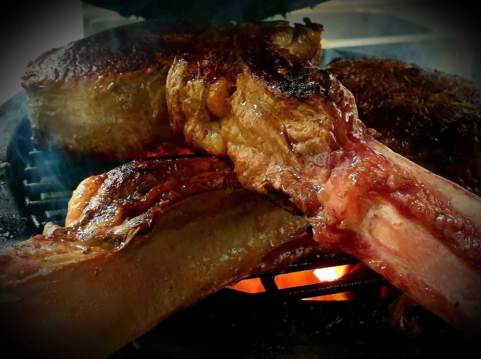 A close-up of a grilled steak with visible char marks and juices.