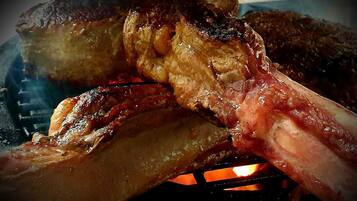 A close-up of a grilled steak with visible char marks and juices.