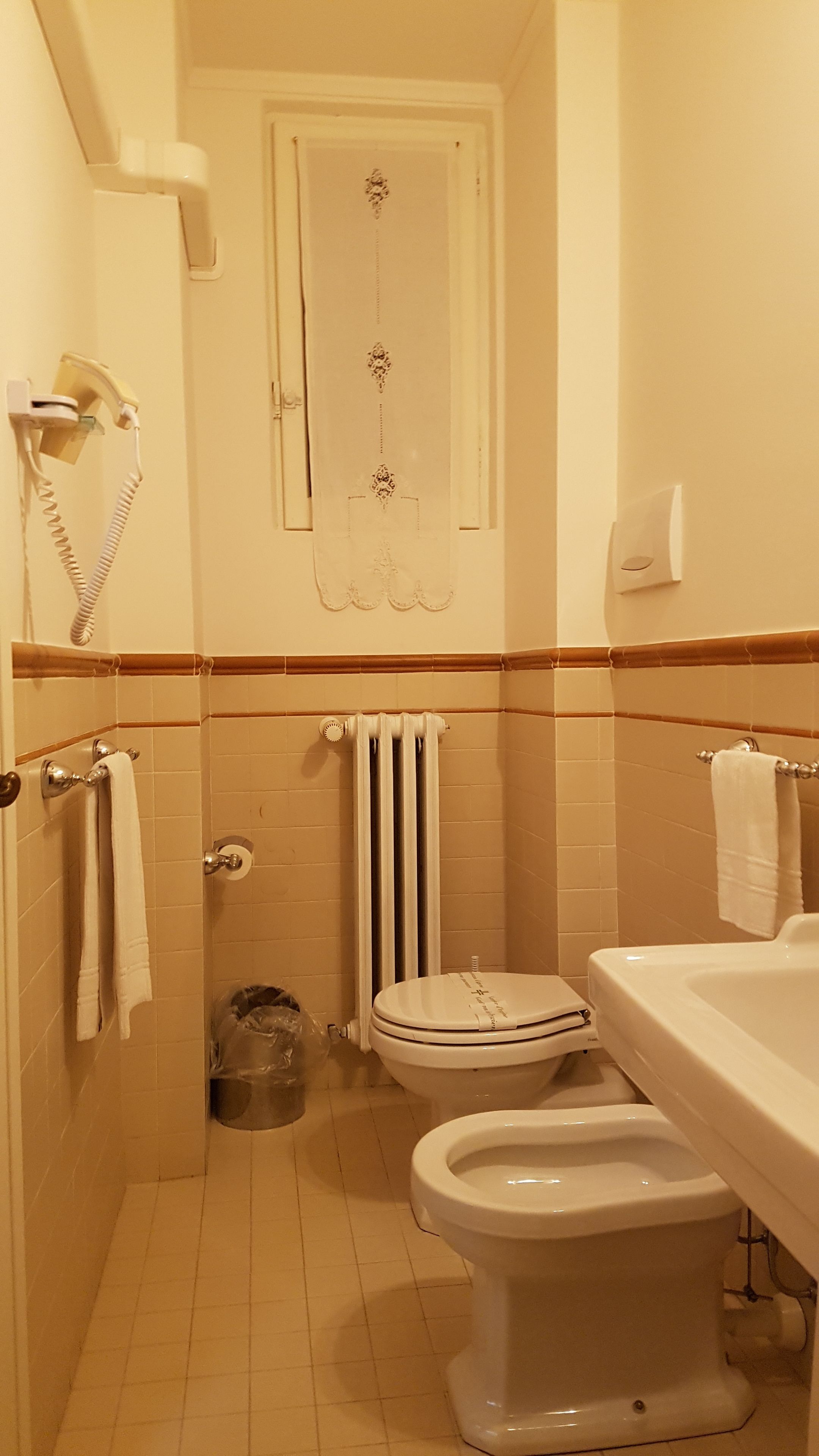 Un bagno con un WC, un bidet e un lavandino.