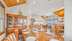 A spacious dining area with a large wooden table set for six, surrounded by wooden chairs. - Semi-Oceanfront Hatteras Home with Private Pool, Hot Tub, Game Room and Wet Bar (Hatteras)