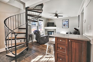 A modern kitchen with a built-in island, a spiral staircase, and a fireplace. - Bubba's Blue Bungalow WALK to Lifts and Main St (Park City)