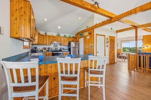 A spacious kitchen with wooden cabinets and a central island with bar stools.