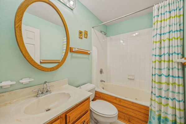 A bathroom with a sink, toilet, and bathtub.