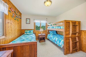 A room with two bunk beds, a window with a view, a small table with a lamp, and a wall decorated with fish. - Canalfront Dog Friendly Home w/ Hot Tub, Dock, Foosball. A Sun Kist Experience! (Avon)