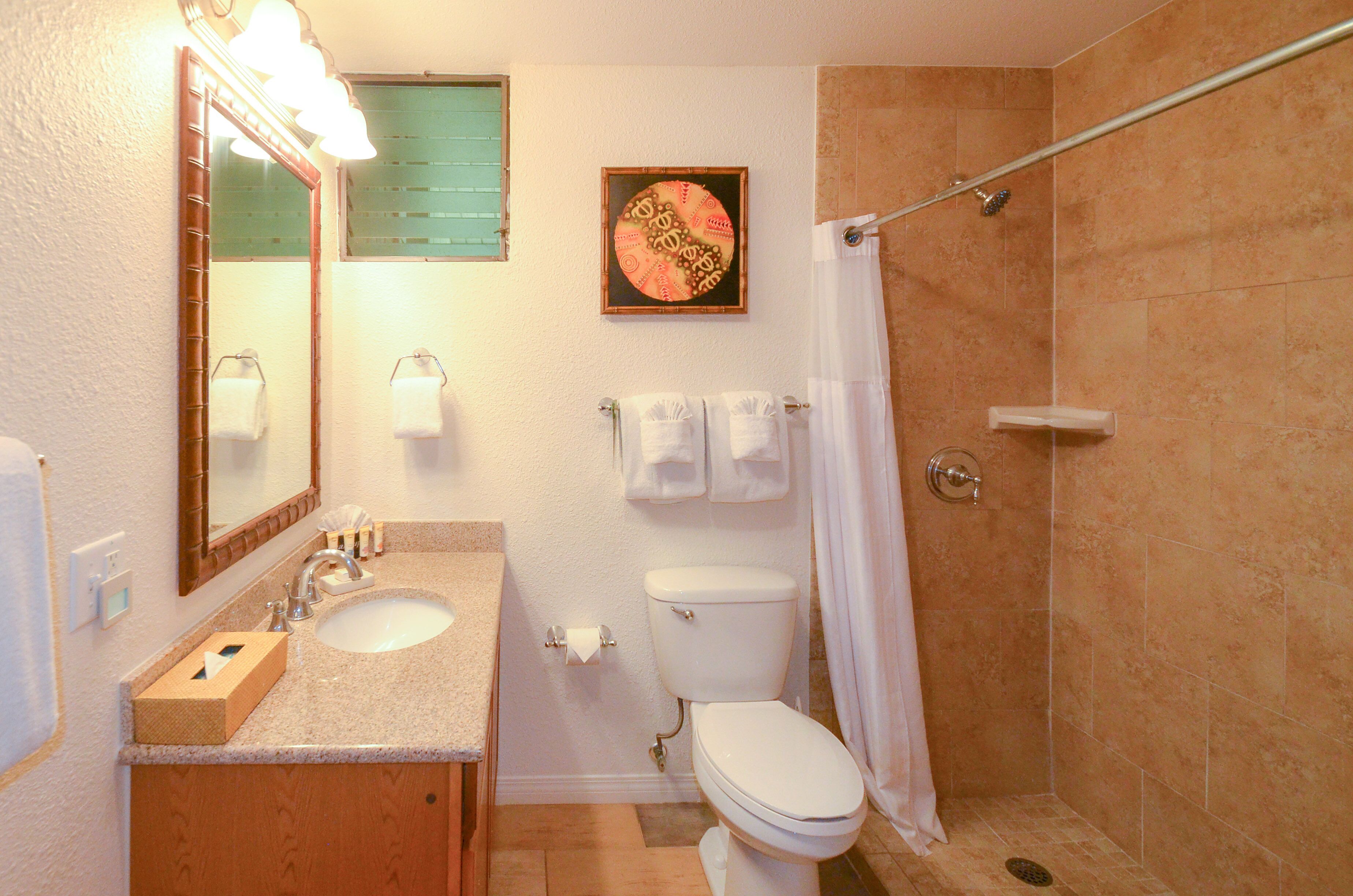 A bathroom with a sink, toilet, and shower.