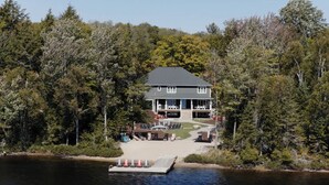A lakeside lodge with a dock, surrounded by dense forest.
