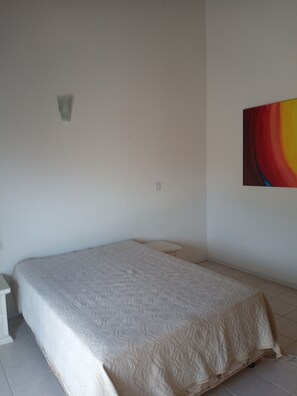 A bedroom with a bed, a small bedside table, and a wall-mounted light. - Penthouse with Fantastic Sea View, Pool and Barbecue on Large Terrace (Cachoeira do Bom Jesus)