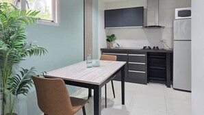 Eine kleine Küche mit Essbereich, einem Blumentopf und einem Fenster.