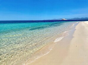 Una playa con agua turquesa cristalina y una orilla arenosa.