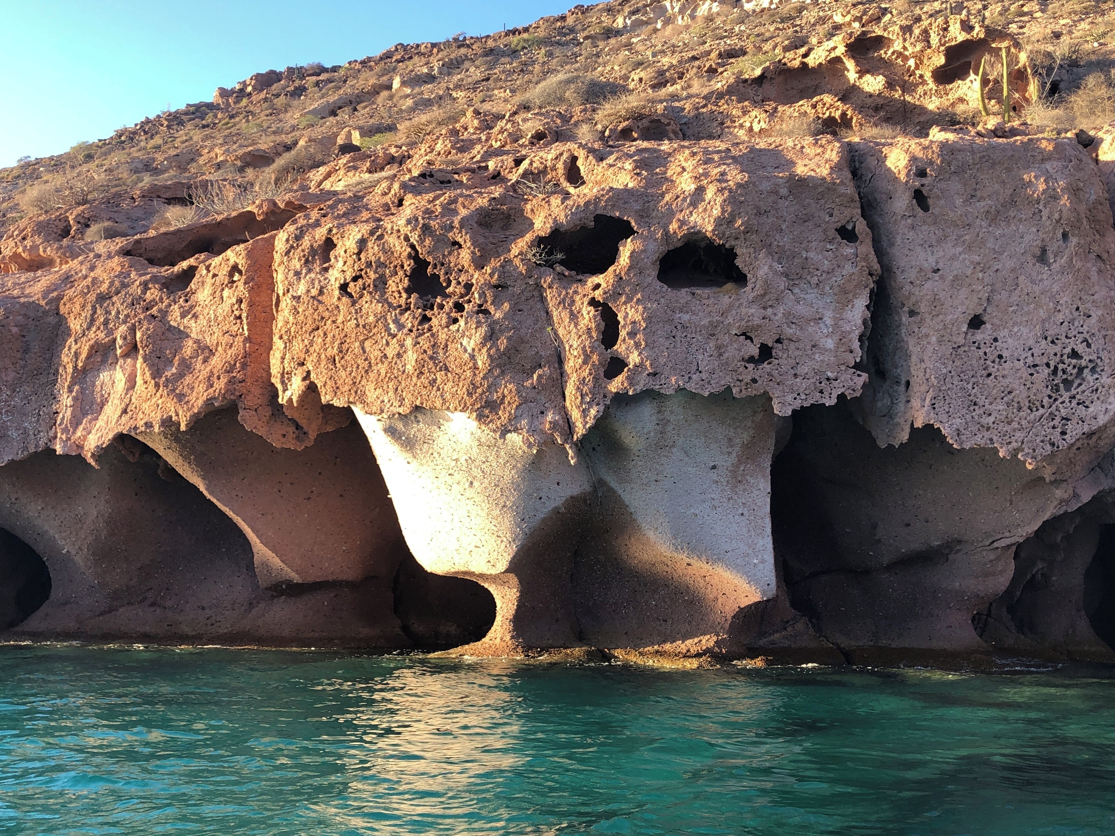 A rocky coastal landscape with clear turquoise water.