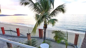 Un balcón con vista a la playa y al océano.